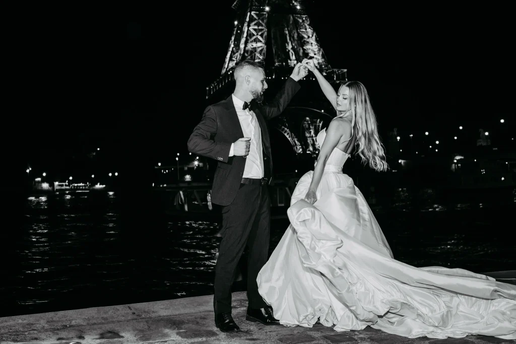 Brautpaar hält Händchen und läuft vor dem Eiffelturm in Paris während Hochzeitsfotos.