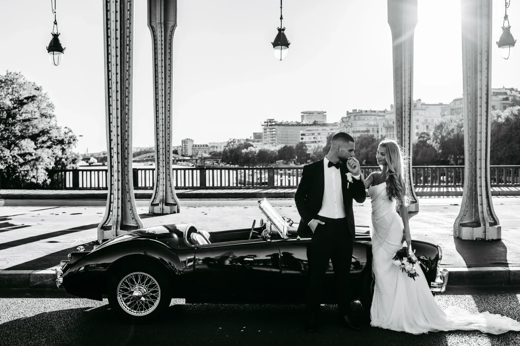Brautpaar küsst sich neben einem klassischen Oldtimer in Paris