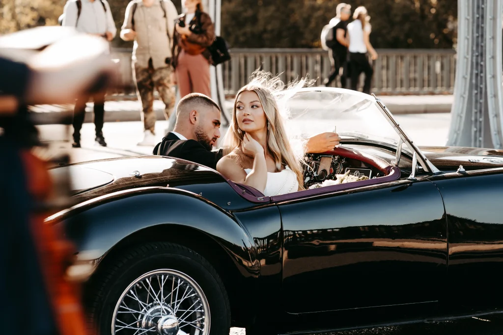 Brautpaar sitzt im Oldtimer in Paris während Hochzeitsfotos