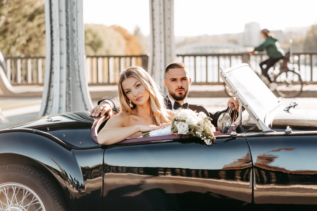 Brautpaar steht neben Oldtimer in Paris bei Sonnenuntergang.