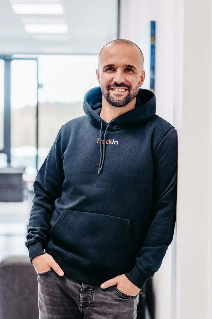 Businessportrait eines stehenden Mitarbeiters, der am Laptop arbeitet