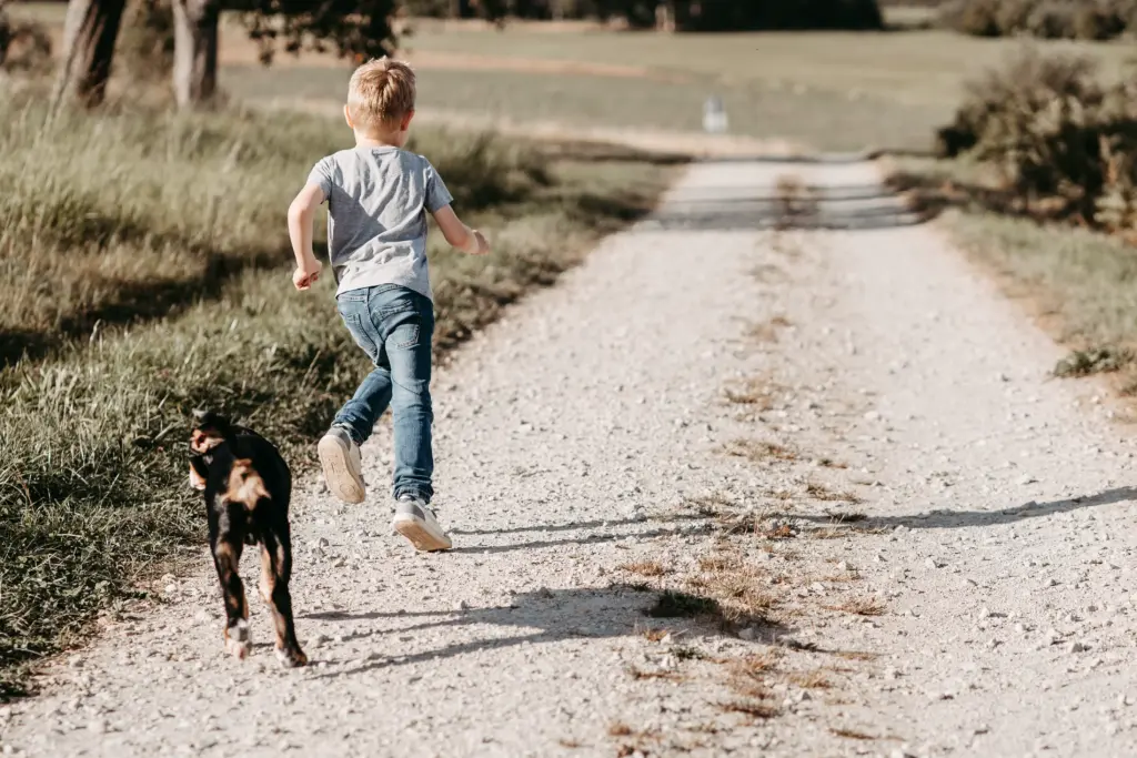 amilie geht Hand in Hand mit Hund durch das Feld bei Koblenz.