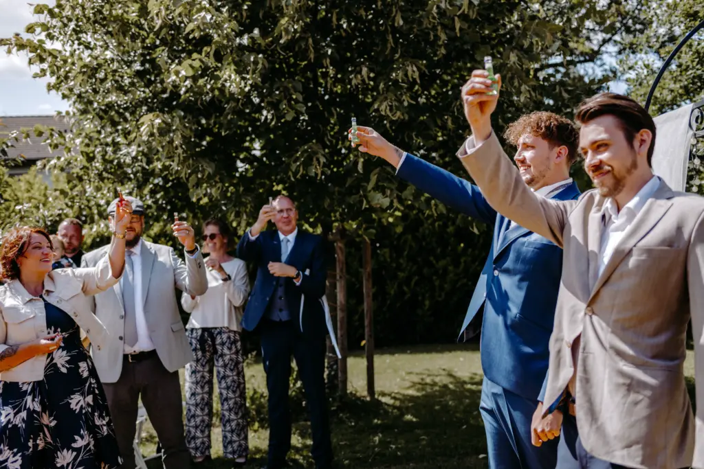 Braut und Bräutigam halten sich während der Trauung an den Händen.